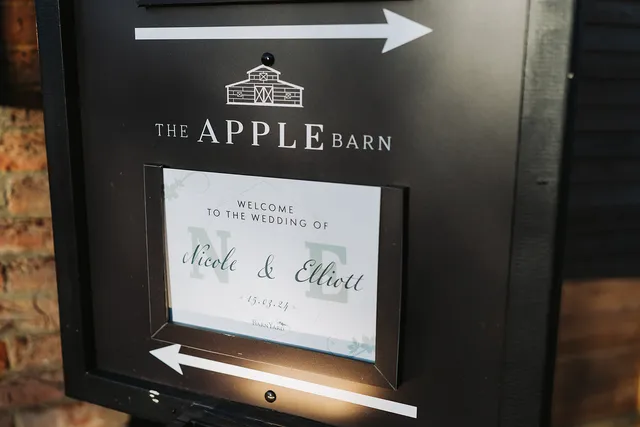 The lit welcome sign at the entrance to an Apple Barn wedding