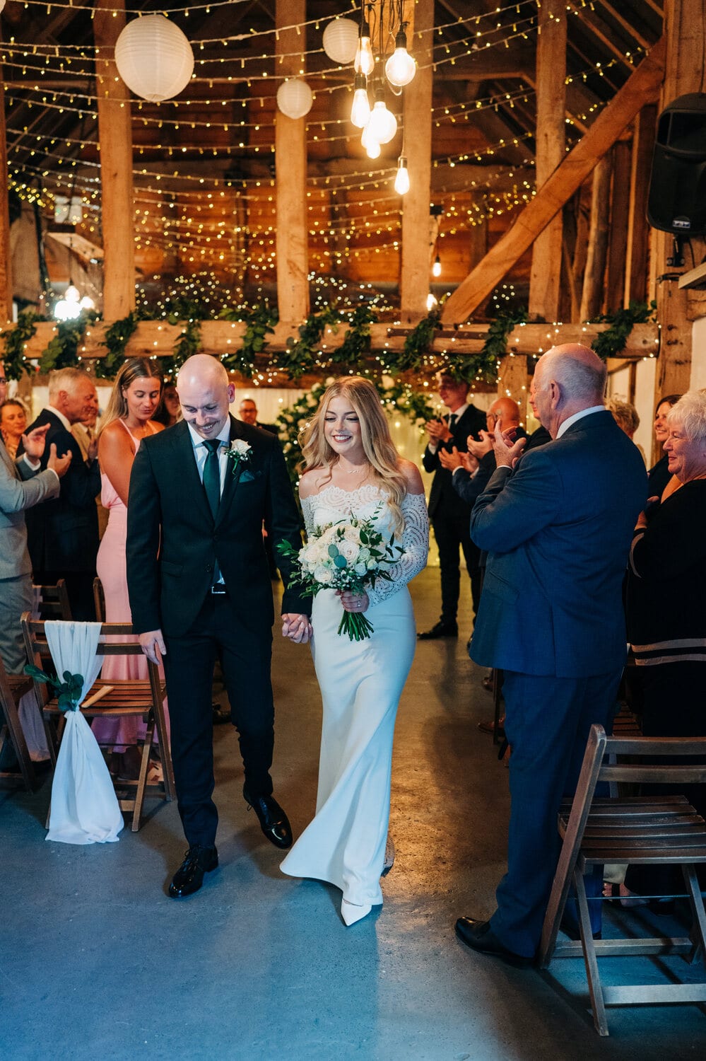 Guests celebrate a ceremony in the fairy-lit Apple Barn