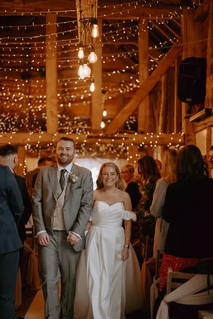 A newly married couple at the end of the aisle in the Apple Barn