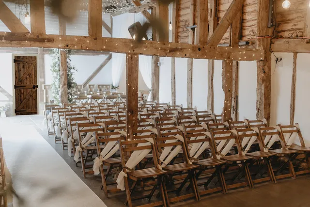 Rows of wooden chairs set for a ceremony in the Apple Barn