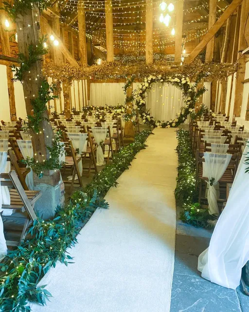 The Apple Barn aisle laid with a white runner and greenery either side