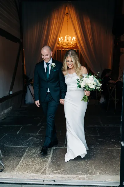 A newly married couple walk out of the Apple Barn hand in hand