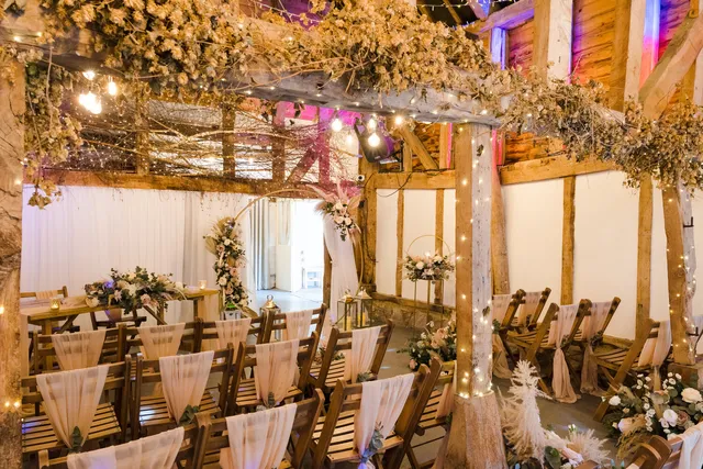 Ceremony chairs and florals beneath the Apple Barn's oak beams