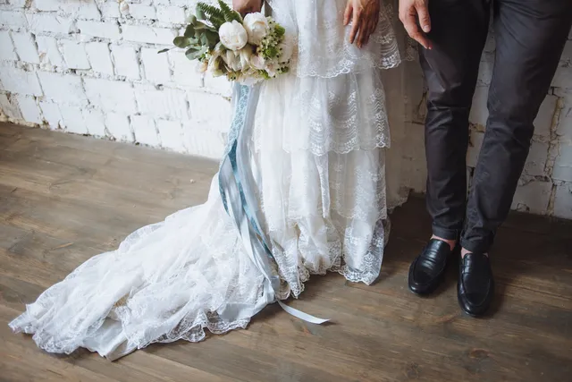 A bride's dress and bouquet laid out before the wedding breakfast