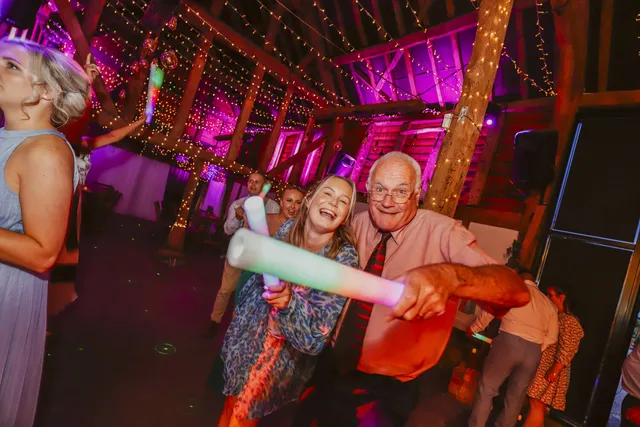 Guests dancing under coloured lights at an evening reception