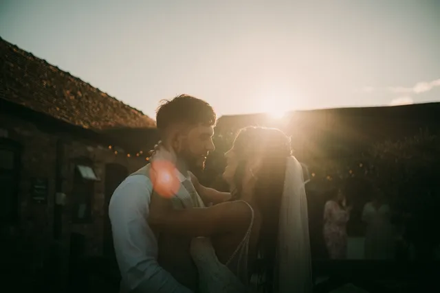 A couple share a quiet moment at golden hour at The BarnYard