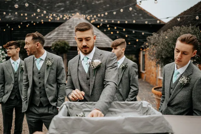 Groomsmen in grey three-piece suits outside the Apple Barn
