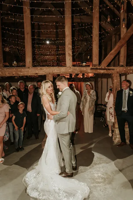 A couple's first dance in the fairy-lit Apple Barn