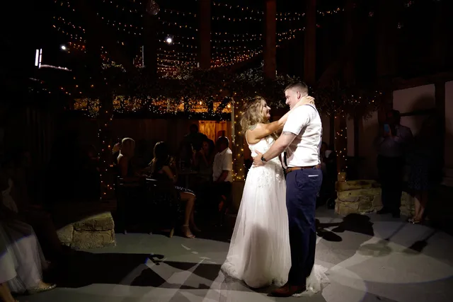 A couple dance together at their Apple Barn reception