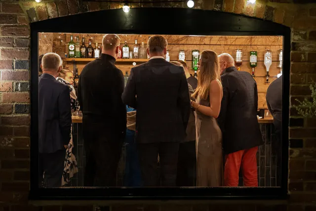 Guests gathered at the bar at an Apple Barn wedding