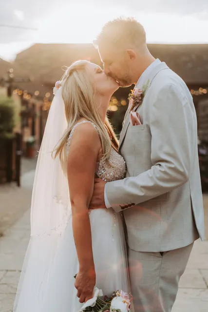 A couple kiss at their Apple Barn wedding