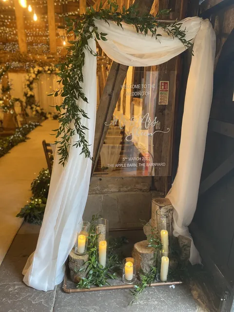 Draped fabric, greenery and candles at the Apple Barn entrance