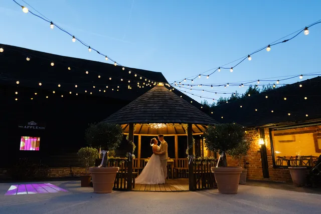 The Courtyard gazebo lit up beneath festoon lights at dusk