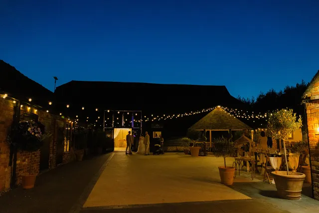 The Courtyard and barns lit by festoon lights after dark