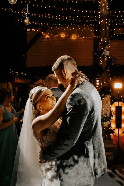 A couple dance closely under the fairy lights