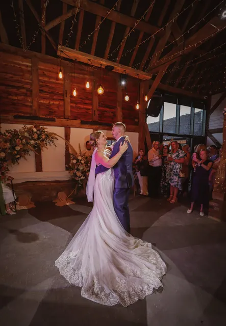 A couple's first dance as guests watch in the Apple Barn