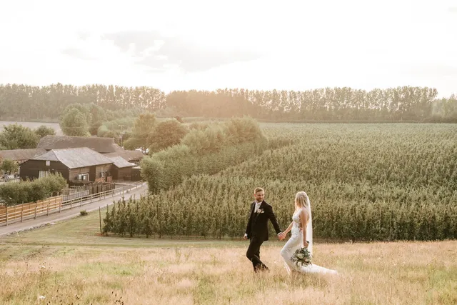 A couple walking through the fields at sunset