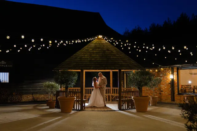 A bride in the Courtyard gazebo, lit against a blue evening sky