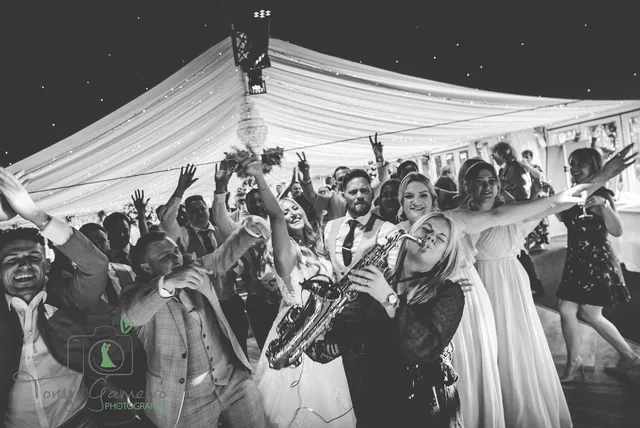 Guests dancing with a saxophonist in the Arboretum