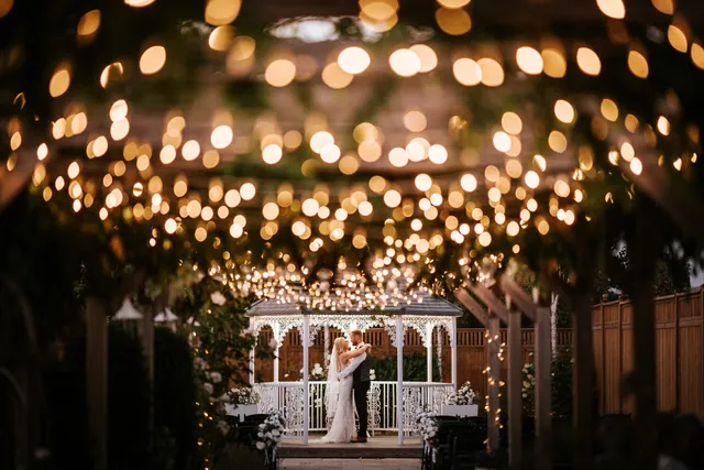 A couple at the gazebo under a canopy of lights