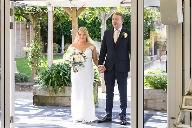 A couple in the Arboretum doorway with the gardens behind