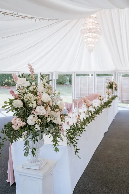A top table dressed with blush and white florals