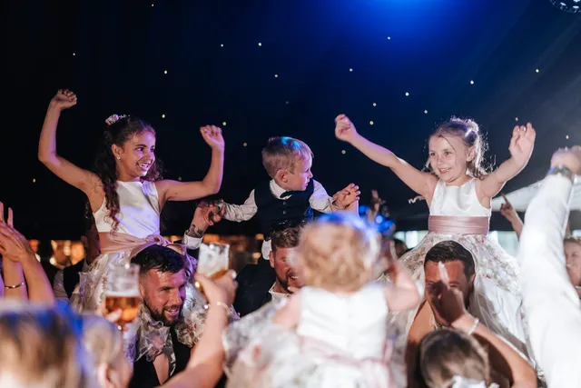 Children on shoulders on the dance floor