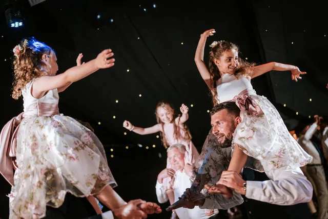 Guests dancing with children on their shoulders