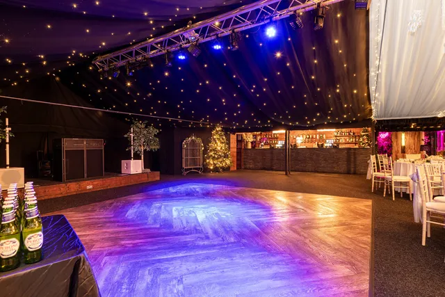 The Arboretum dancefloor lit purple and gold for a Christmas party