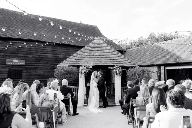 A couple's first kiss at the Courtyard gazebo, in black and white