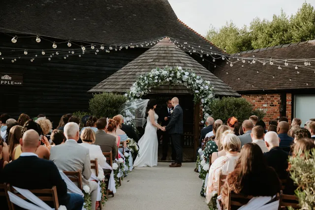 A bride and groom at the Courtyard gazebo as guests watch