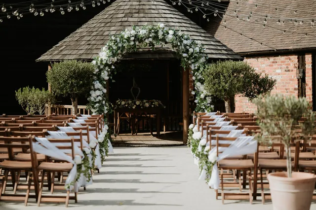 The Courtyard gazebo dressed with a white floral arch for a ceremony