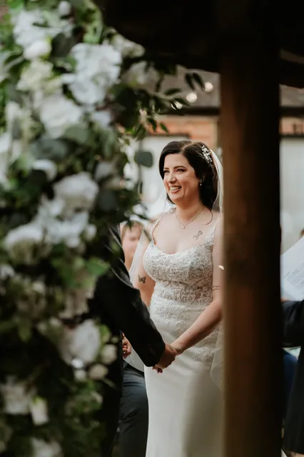 A bride smiles as she walks the Courtyard aisle