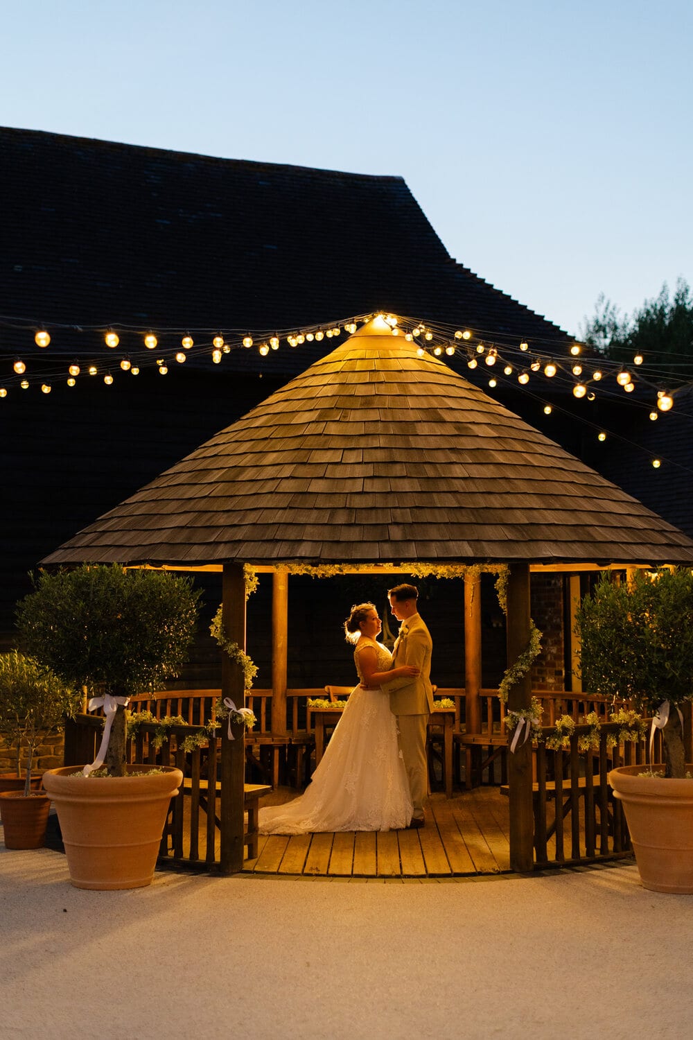 The courtyard gazebo glowing with fairy lights at dusk