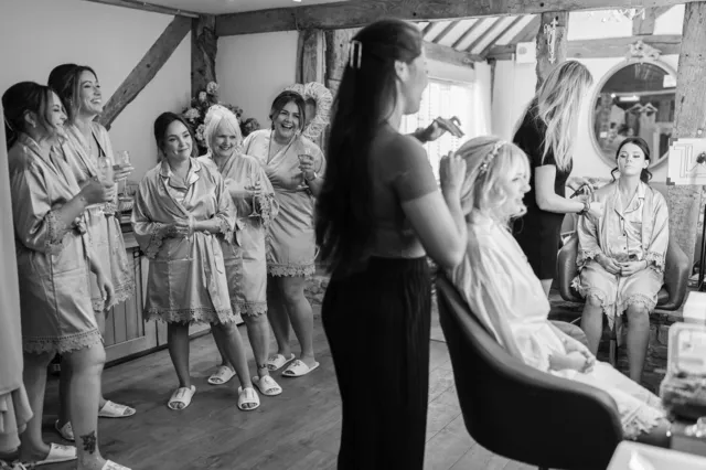 Bridesmaids laughing together while the bride gets ready