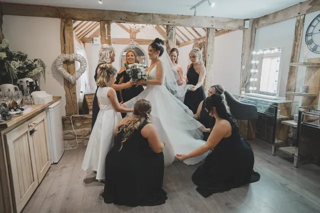 The bridal party helping the bride into her dress