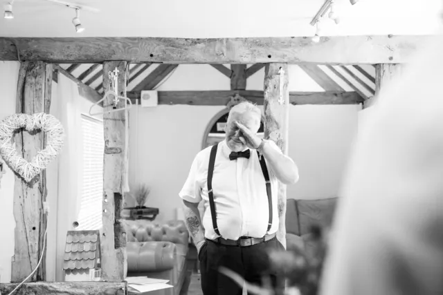 A father wiping away a tear in the dressing suite