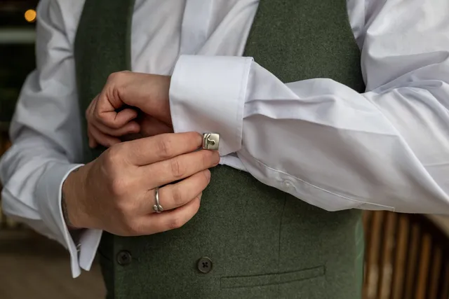 A groom fastening his cufflinks