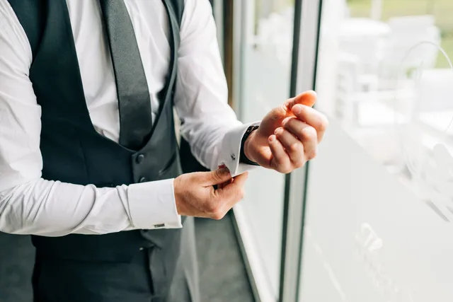 A groom's buttonhole being pinned in place
