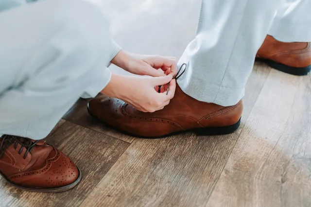 A groom's brogues being laced