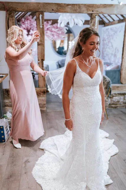 A bridesmaid lifting the bride's veil