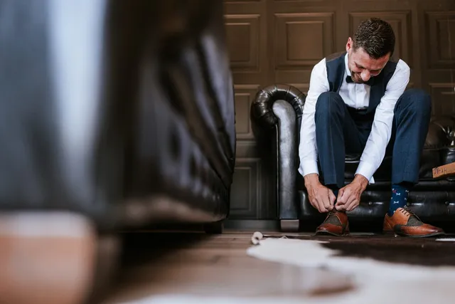 A groom putting on his shoes in the lounge