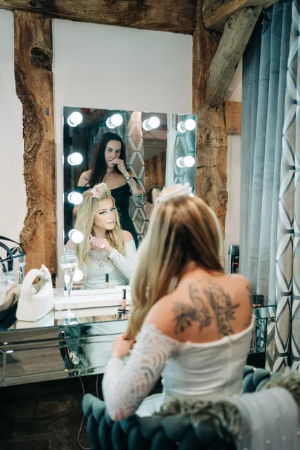 A bride reflected in the lit vanity mirrors