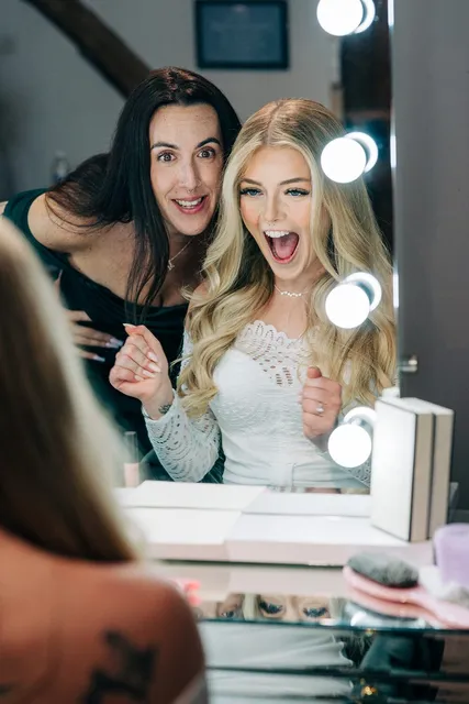 Bridesmaids cheering the bride at the mirror