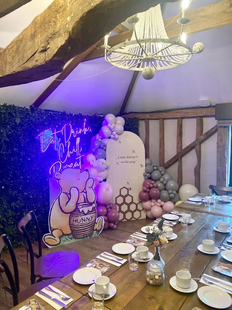 A long table set for a baby shower with a balloon display behind