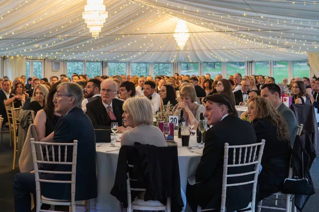 Guests seated at round tables for a celebration in the Arboretum