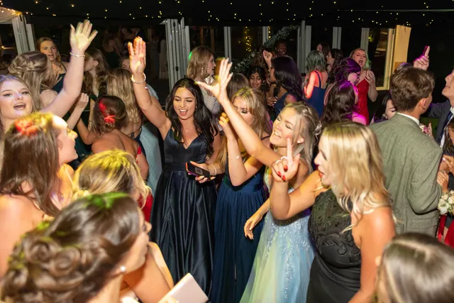 Friends dancing under the fairy lights at a prom
