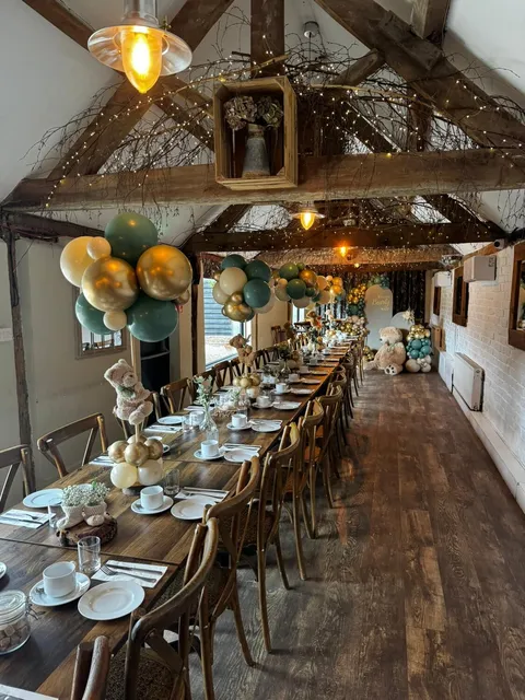 A long table dressed with balloons and greenery for a celebration
