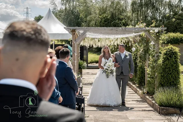 A bride arriving at her ceremony down the lavender aisle