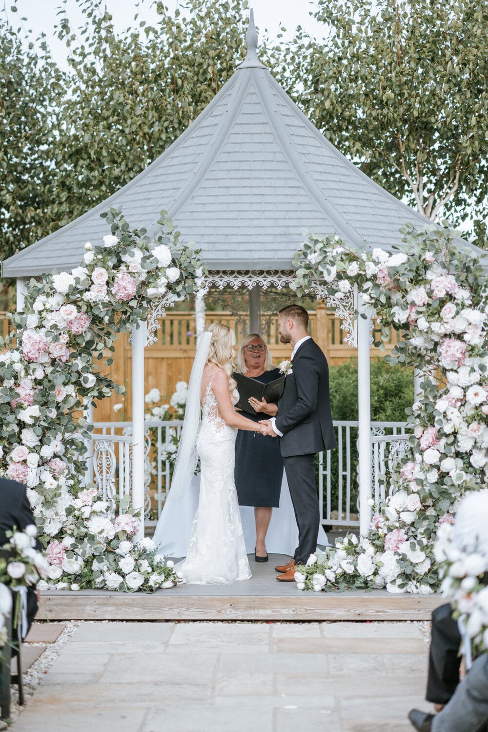 A couple under a leafy green arch on the lavender walk